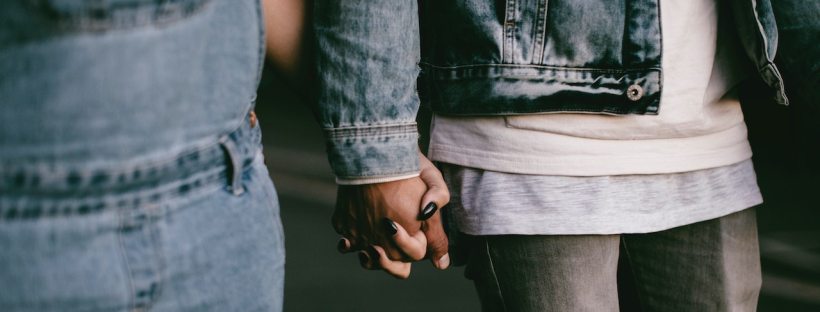 Photo of a Black couple holding hands, cropped in to just their hands clasped together.