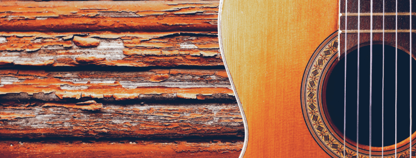 A closeup of a guitar on a wooden background