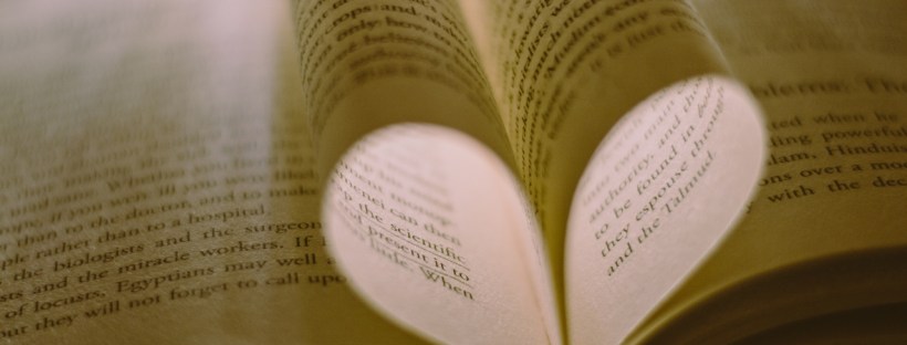 A heart made from two pieces of paper from a book curled inward