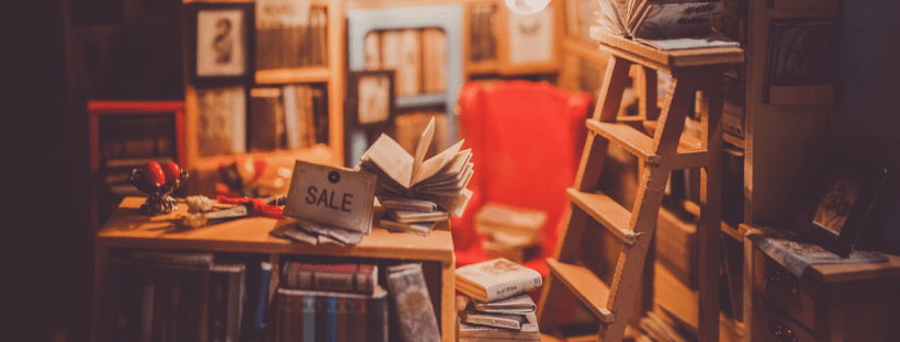 A cute bookstore with a little ladder and a sale sign